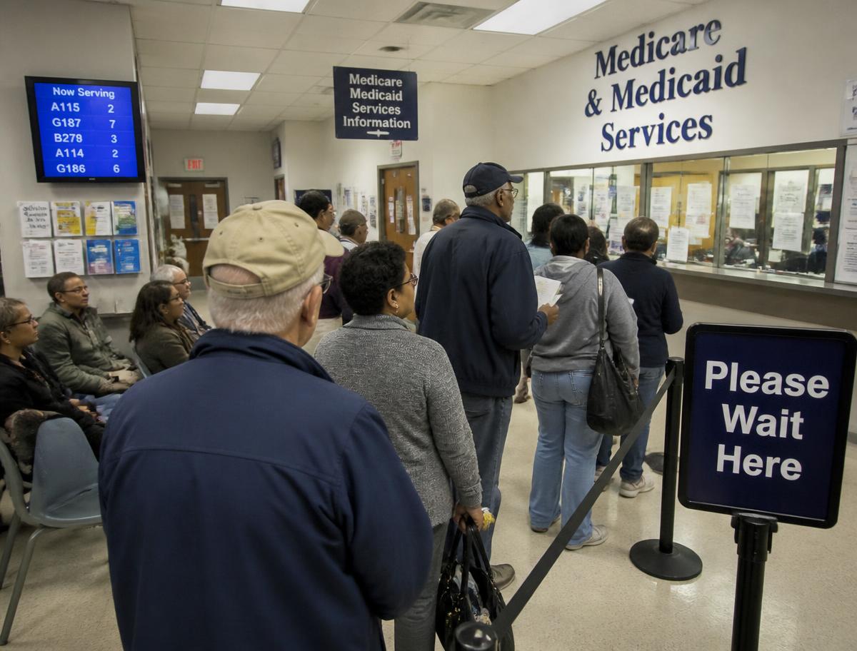 People waiting in line at a Medicare and Medicaid services office counter